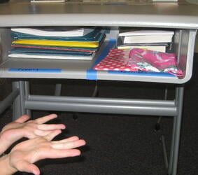 After Executive Function coaching, a student proudly displays her newly organized desk.