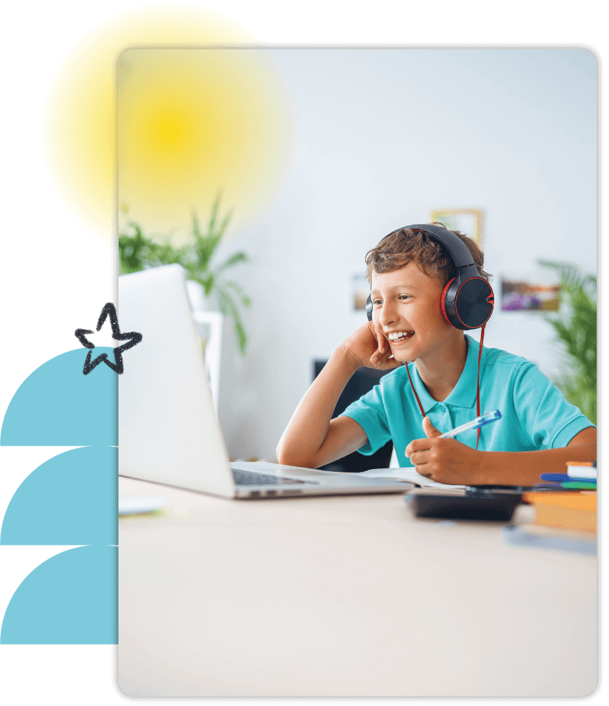 School aged boy with headphones on working on laptop