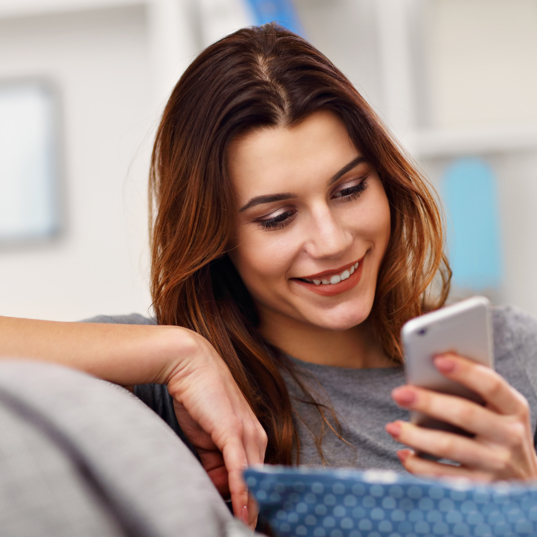 picture of young woman smiling at cell phone